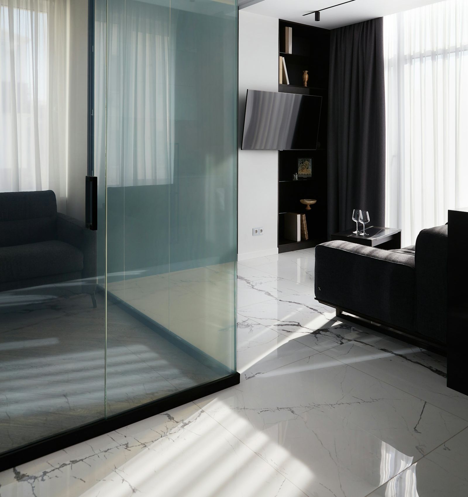 Modern interior with large-format marble-look tile and glass partition